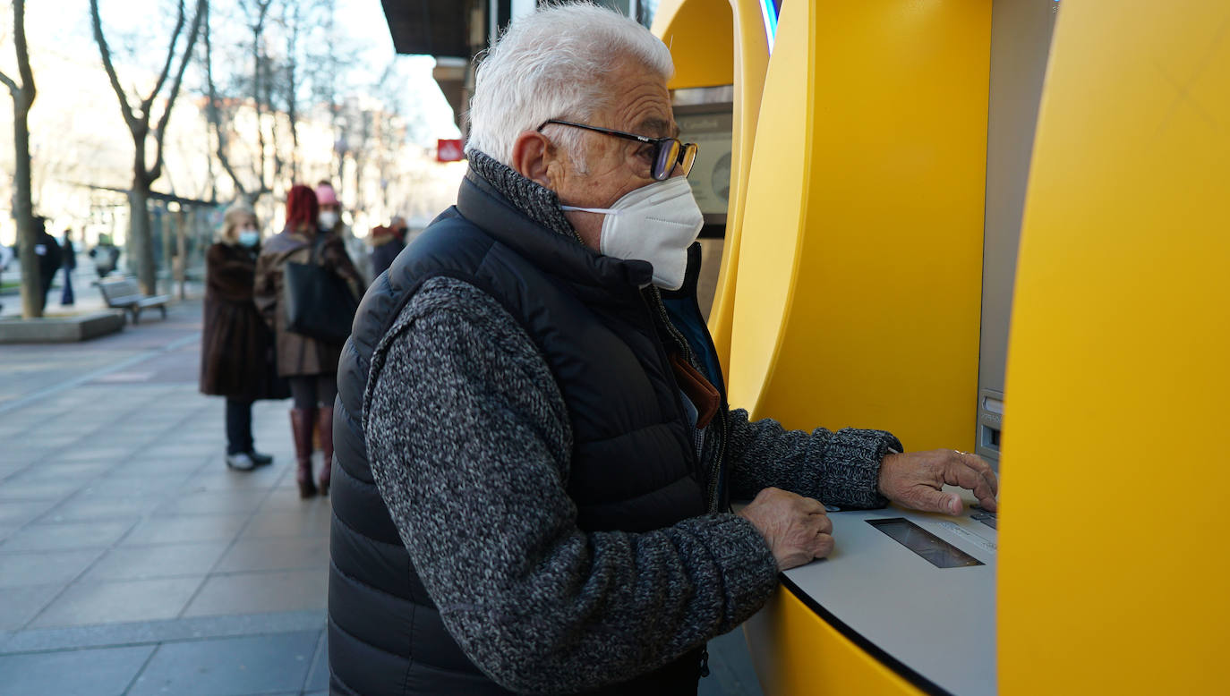 Un hombre de avanzada edad opera en un cajero. 
