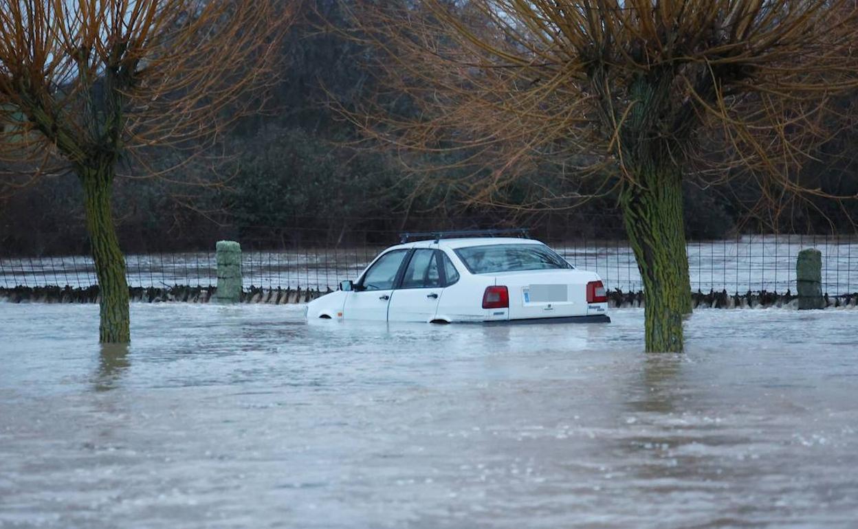 Un coche, casi cubierto por el agua. 