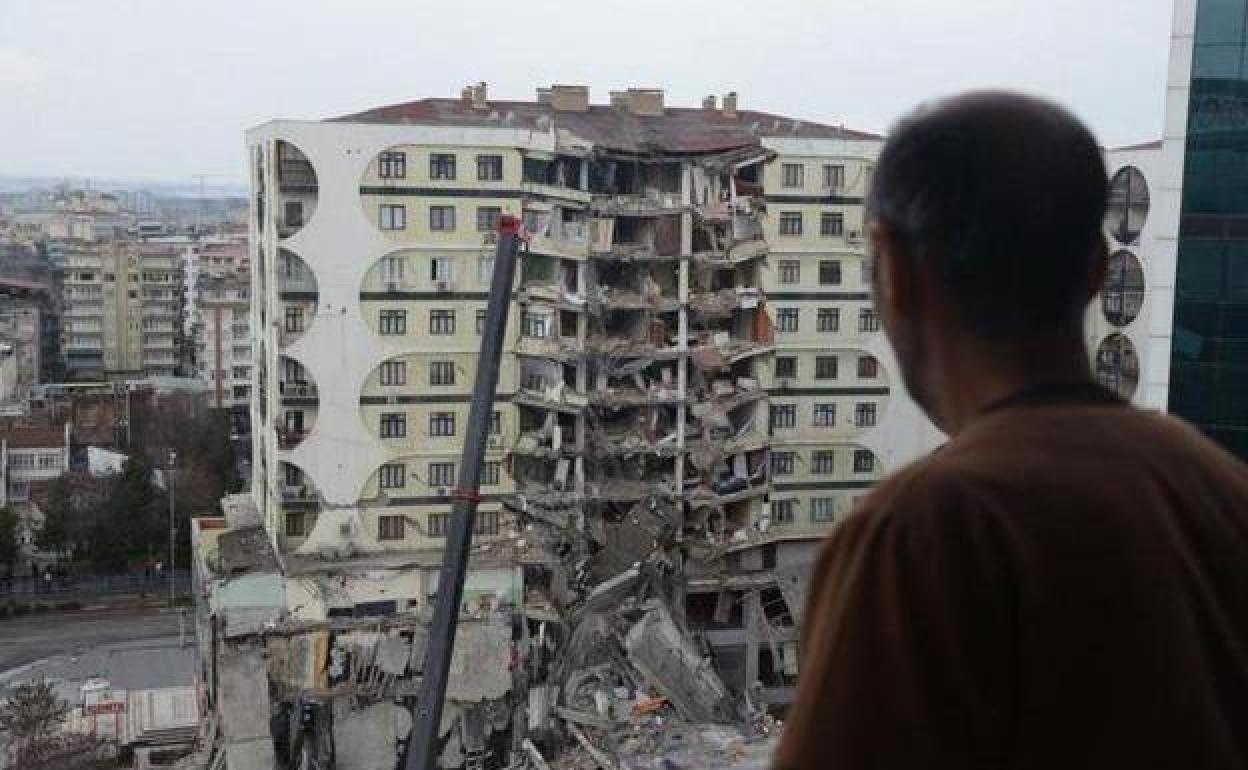 Un hombre observa las operaciones de búsqueda entre los restos de un edificio en Diyarbakir (Turquía)