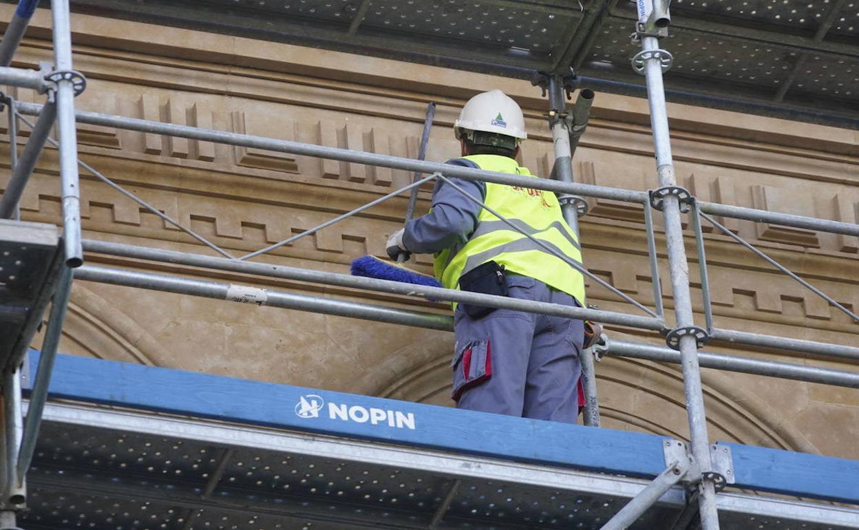 Un operario realiza trabajos en una fachada de un edificio en Salamanca. 