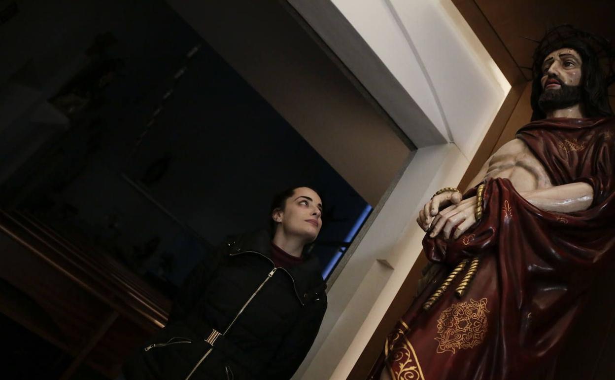 Alicia García, hermana mayor de la hermandad mira una imagen.