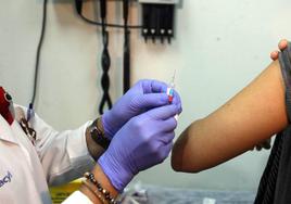 Enfermera poniendo vacuna contra la gripe.