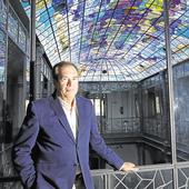 Pedro Pérez Castro posa ante la vidriera con la que el visitante se topa al acceder al Museo Art Nouveau y Art Déco Casa Lis de Salamanca.