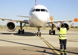 Un avión a su llegada a Matacán en Salamanca siguiendo las indicaciones de un operario.