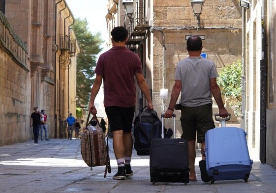 Dos personas con maletas por Salamanca.