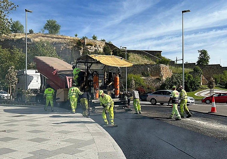 Operarios asfaltando un tramo del paseo de San Vicente en la glorieta de los Sanitarios.