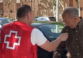 Voluntario de Cruz Roja poniendo una pegatina a un colaborador
