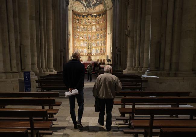 Miguel Ruano, a la derecha, camina hacia el gran retablo de la Catedral Vieja de Salamanca.