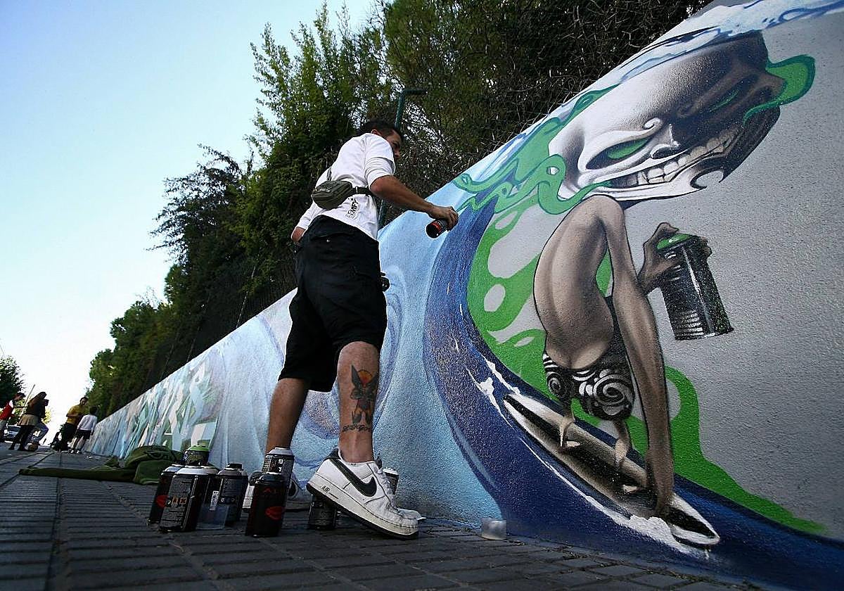 Un joven realiza una grafiti en una imagen de archivo.