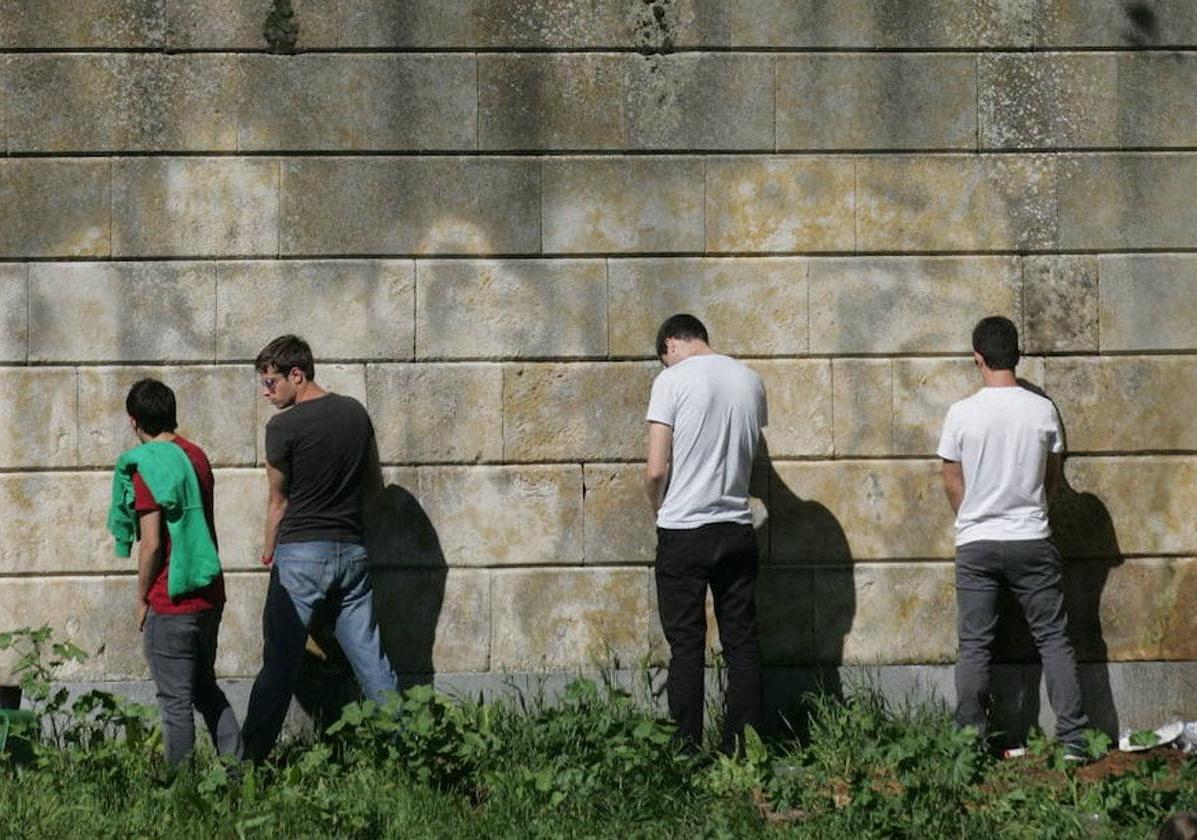 Imagen de archivo de varios jóvenes orinando junto a un muro en la zona del Puente Romano.