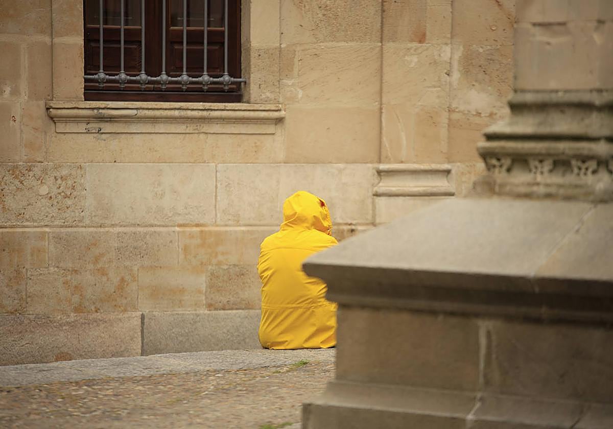 Una persona con un chubasquero para protegerse de la lluvia