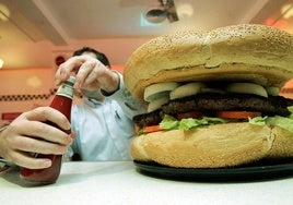 Un ciudadano se dispone a consumir una hamburguesa.