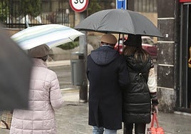 Varias personas pasean con paraguas por Salamanca.