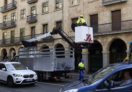 Operarios de la empresa encargada instalando los cables en la Gran Vía.