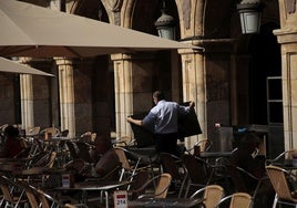 Un camarero preparando una mesa en la Plaza Mayor