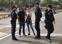 Varios policías de Valencia conversan con dos personas tras la DANA.