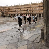 Varias personas se protegen de la lluvia en la Plaza Mayor de Salamanca.
