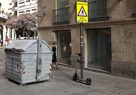 Patinete amarrado a una señal de zona peatonal en una calle de Salamanca.
