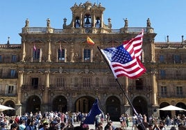 Extranjeros en la Plaza Mayor de Salamanca portando una bandera de Estados Unidos.