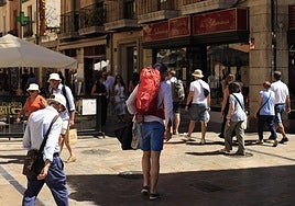 Varias personas pasean por la Rúa con calor.