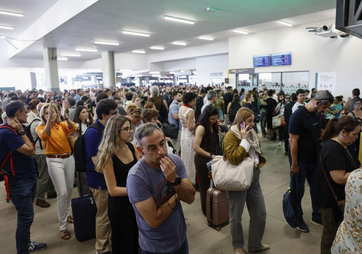 Varios viajeros esperan en Chamartín.