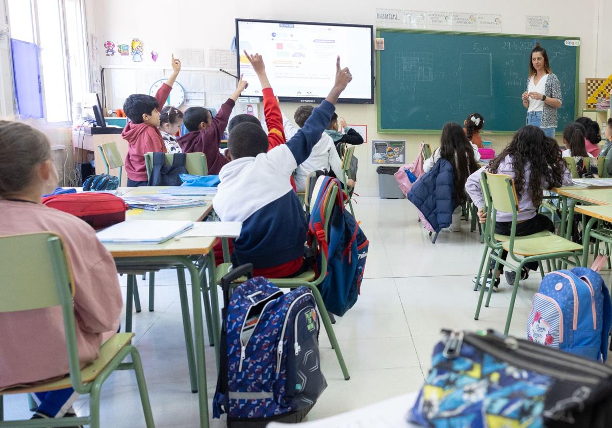 Alumnos de un colegio de Salamanca levantan la mano ante las explicaciones de la profesora.