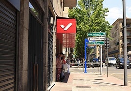 Personas se protegen del sol esperando al autobus en la Gran Vía