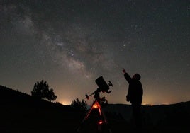 Un hombre junto a un telescopio señalando la Vía Lactea en el observatorio astronómico 'El Cielo de Salamanca'.