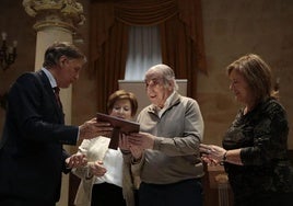 Carlos García Carbayo hace entrega de una placa a un matrimonio por sus bodas de oro.