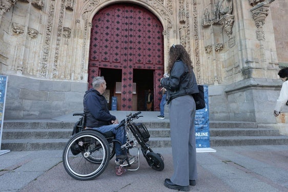Imagen de archivo de una persona en silla de ruedas en la puerta de la Catedral de Salamanca.