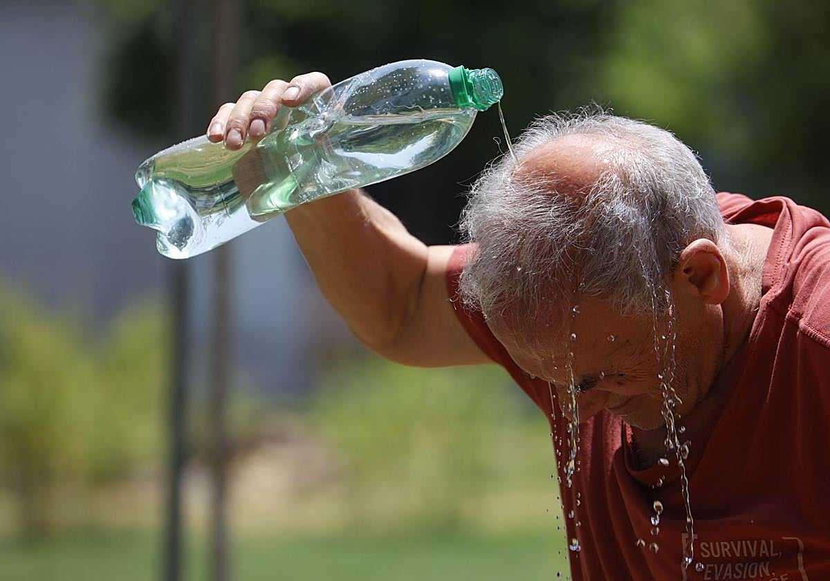 Imagen de archivo de un hombre refrescándose con una botella de agua.