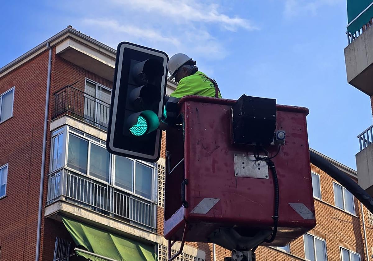 Un trabajador manipula un semáforo en la ciudad.