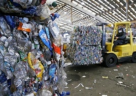Montacargas mueve botellas de plástico listas para reciclarse.
