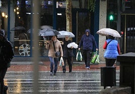 Varias personas pasean con paraguas por Salamanca en un día de lluvia.