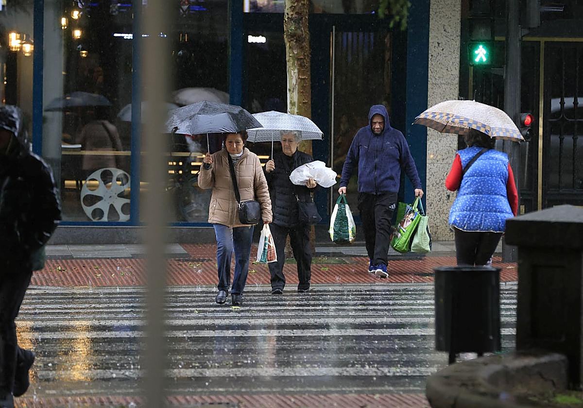 Varias personas pasean con paraguas por Salamanca en un día de lluvia.