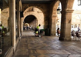 Imagen de una mujer barriendo los soportales de la Plaza Mayor de Salamanca.