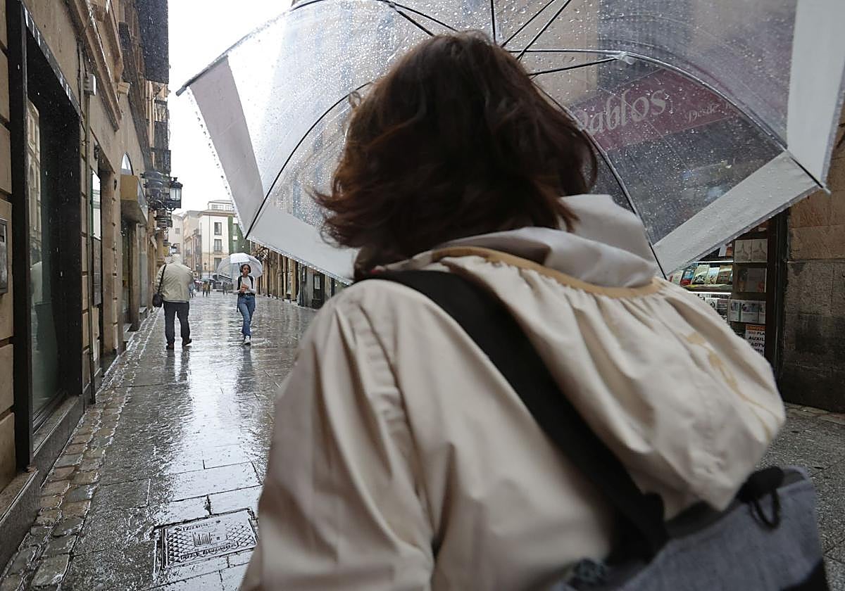 Una persona pasea con su paraguas por una céntrica calle de Salamanca.