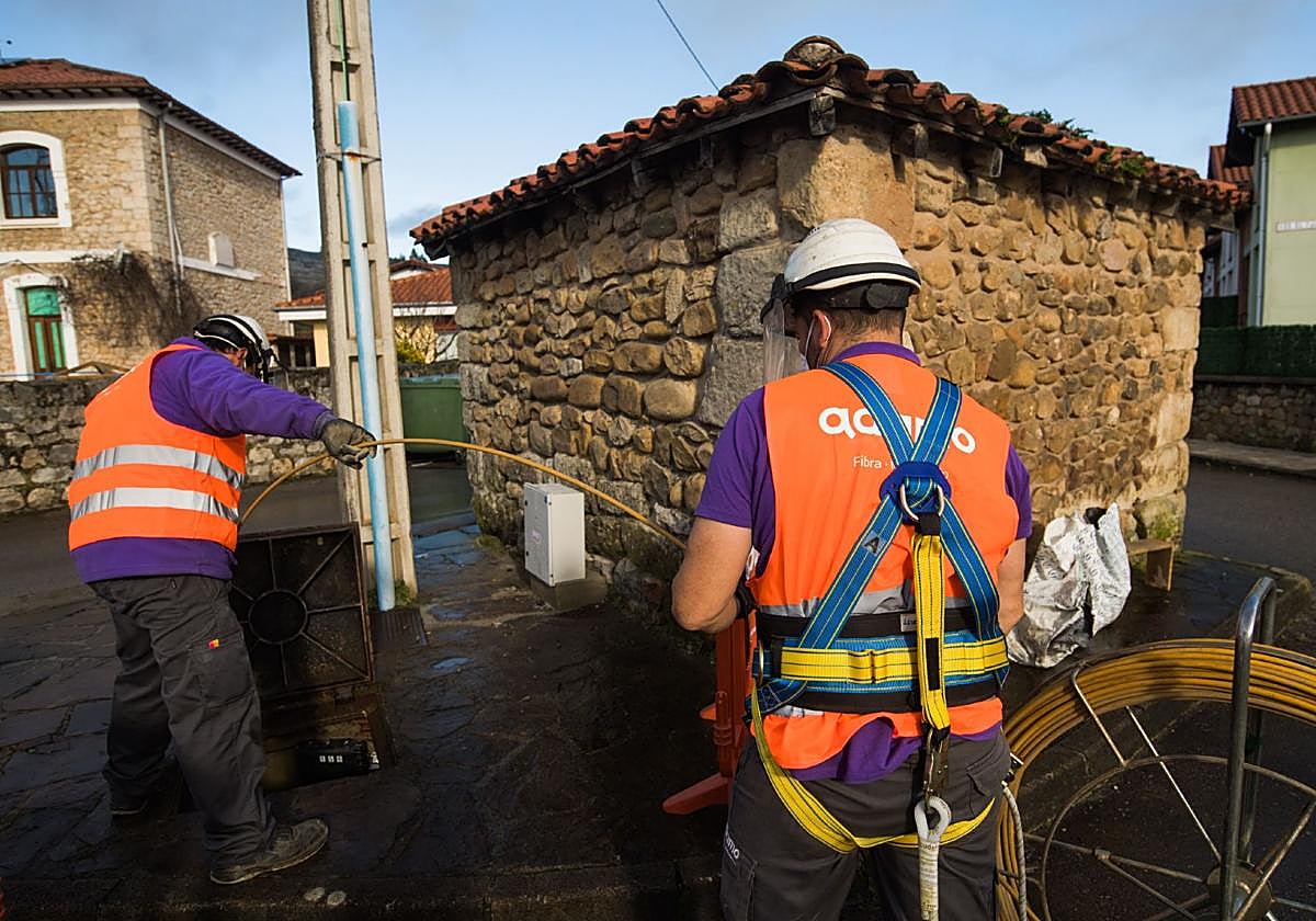 Operarios de la empresa de telecomunicaciones instalan la fibra óptica.