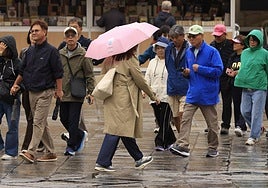 Varias personas pasean por la Plaza Mayor de Salamanca en un día de lluvia.