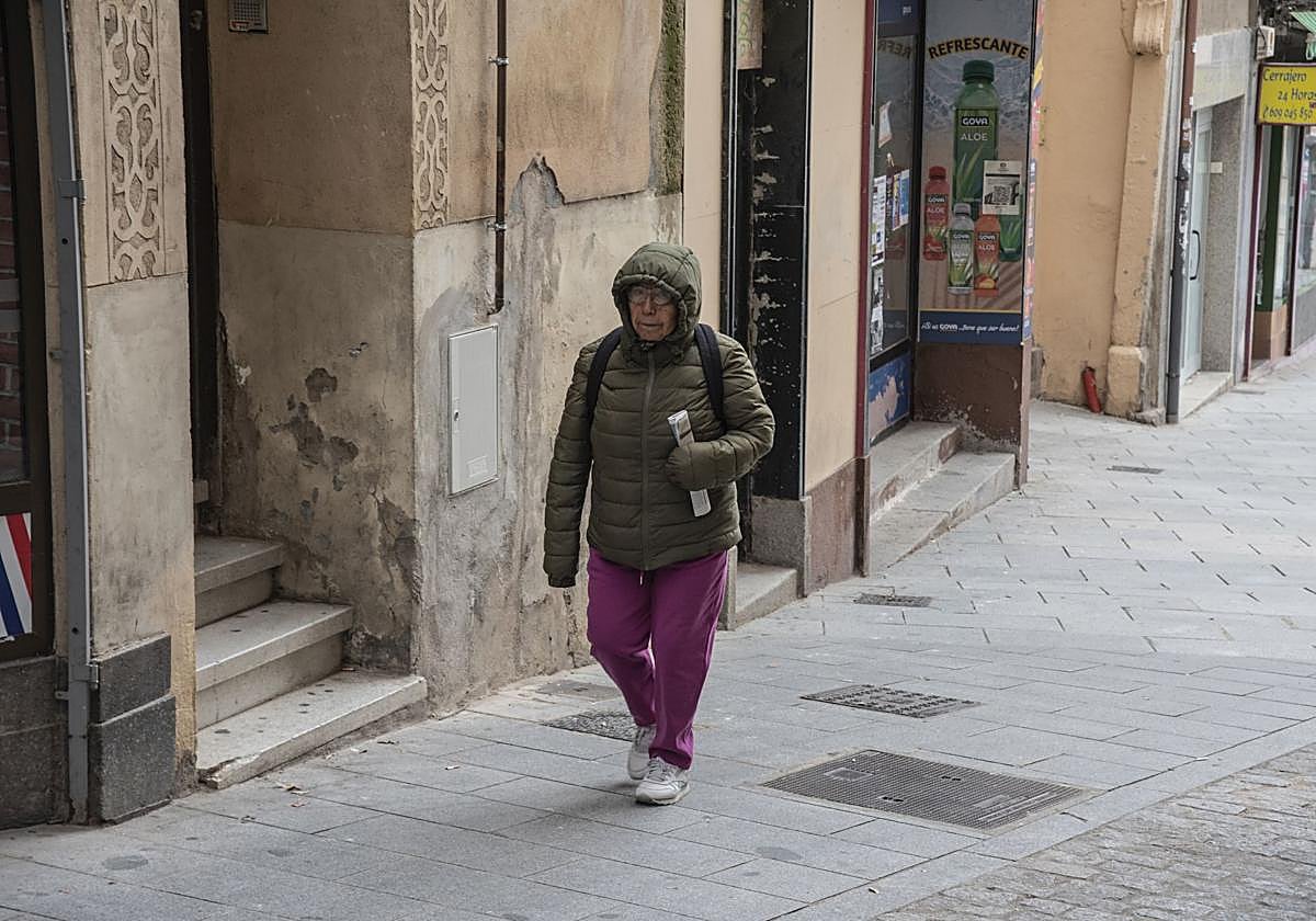 Una señora con capucha en una fría mañana dando un paseo.