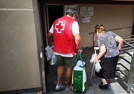 Un voluntario ayuda a una persona mayor a subir sus pertenencias.