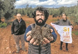 Landwirt Ángel Delgado mit einer Handvoll Erde aus Campo de Montiel, wo ein Bergbauunternehmen nach Neodym sucht. Hinter ihm: Raquel Pérez und Miguel Fuentes.