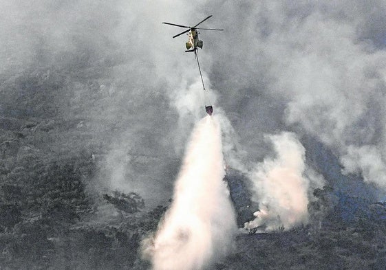 Ein Hubschrauber bekämpft den Brand in der Sierra de la Plata in Tarifa (Cádiz).