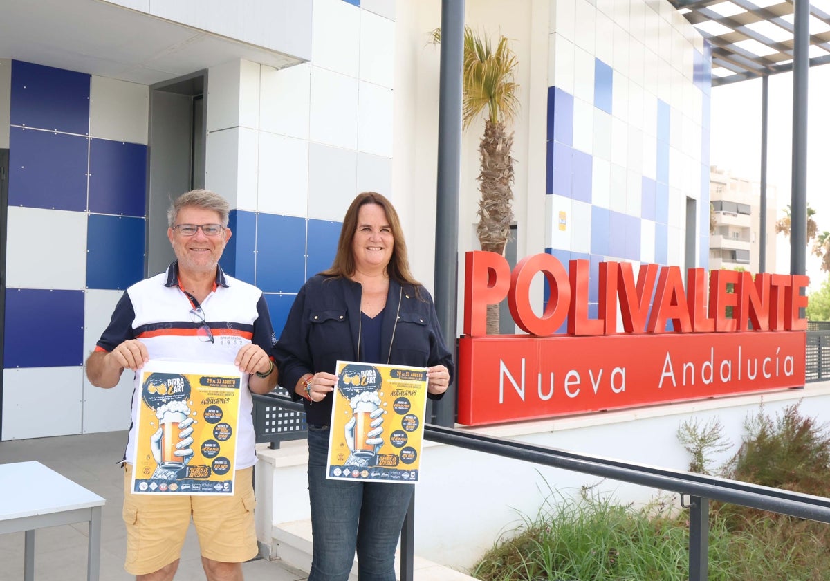 Bezirksrätin Vanessa Ortiz de Zárate und Festivalorganisator José Miguel Macías posieren mit dem Plakat für die Veranstaltung im Espacio Polivalente in Nueva Andalucía.