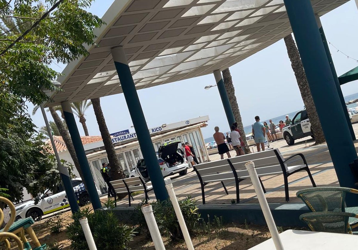 Beamte der örtlichen Polizei und der Guardia Civil, am Mittwoch an der Strandpromenade, mit einem der beiden Verhafteten.