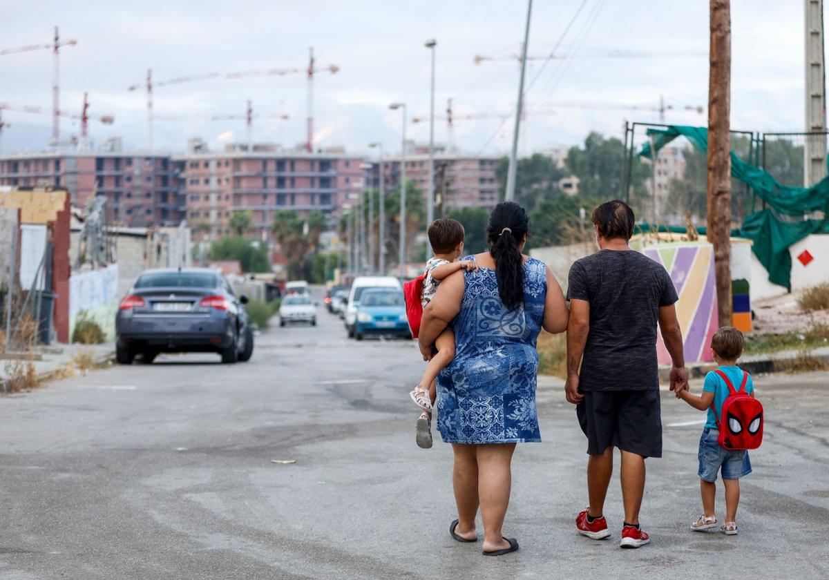 Eine Familie im Armenviertel Los Asperones, im Hintergrund die Baukräne für eine Neubausiedlung.