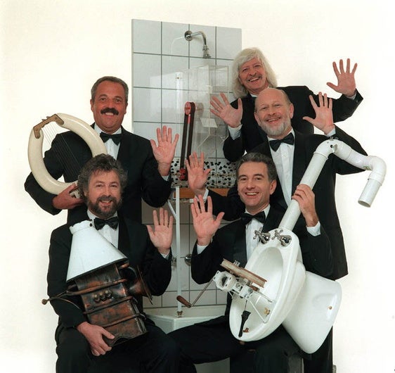 Mitglieder der Gruppe Les Luthiers mit typischen Instrumenten.