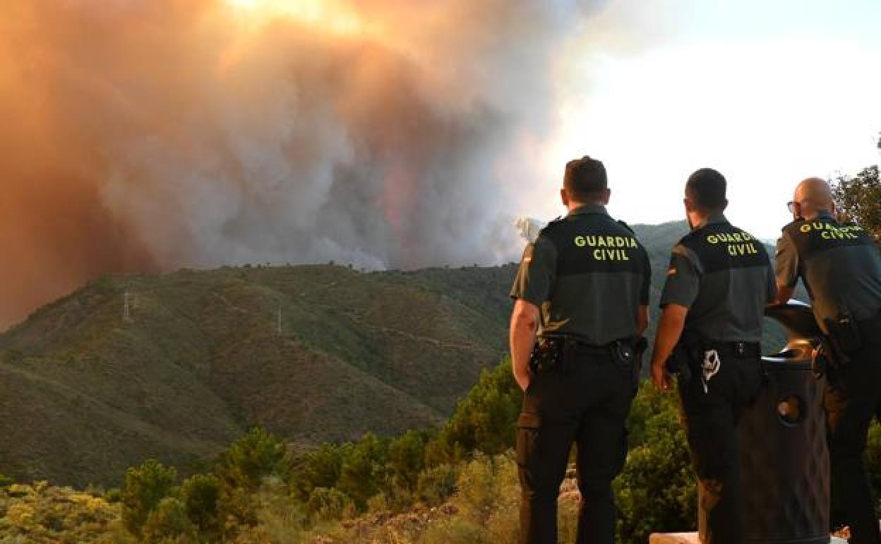 Guardia Civil officers watch the evolution of the fire in the Sierra Bermeja.