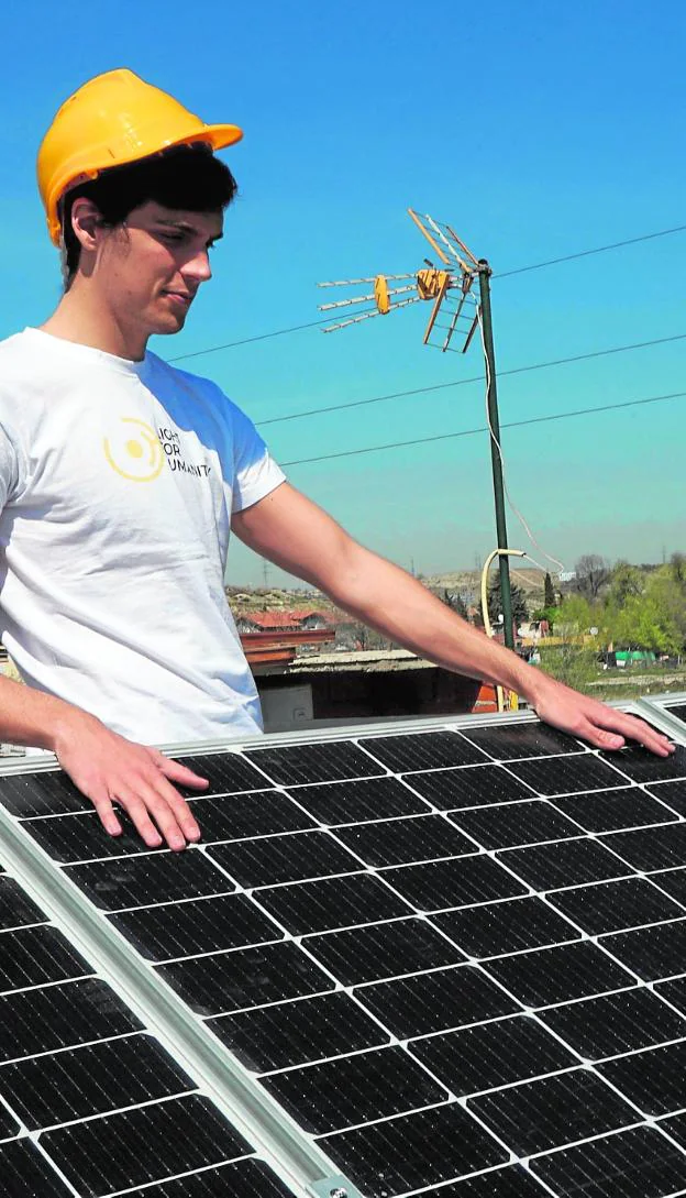A technician installs solar panels on a private house. 