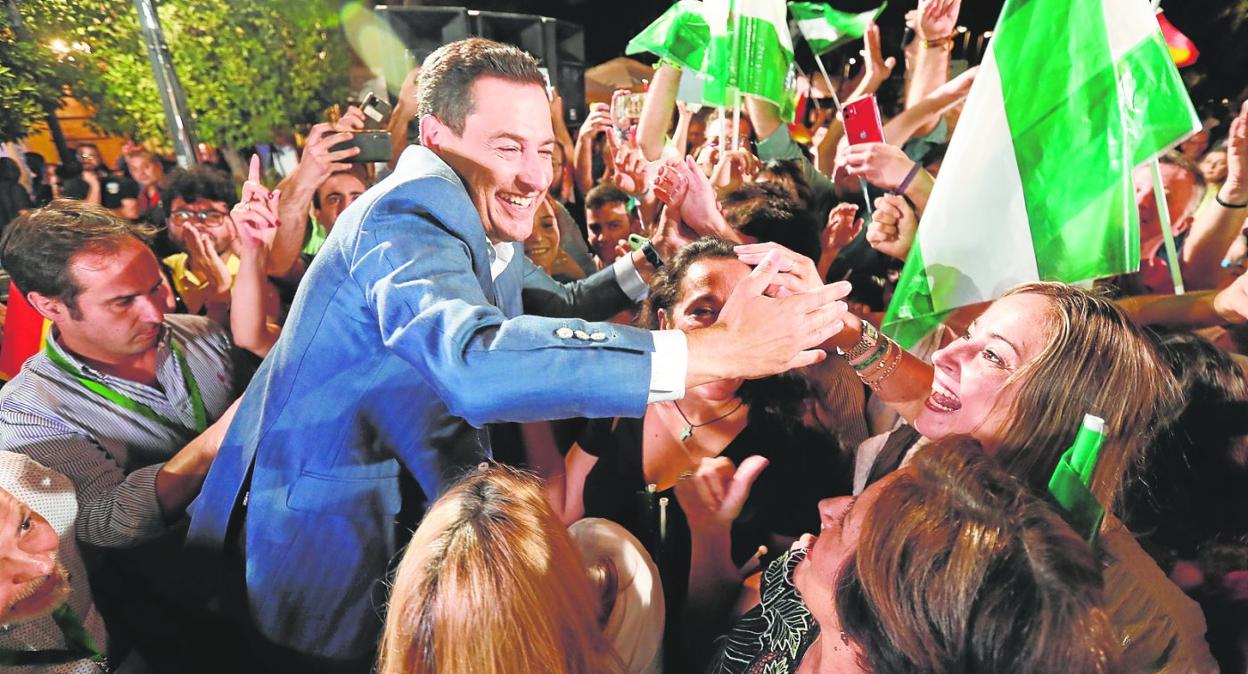 Juanma Moreno, leader of the Andalusian Partido Popular, celebrates his victory with supporters in Seville on Sunday night. 
